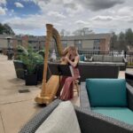 A harpist plays outside on the patio