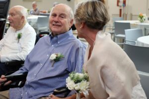 A senior man smiles at his wife during their vow renewal.