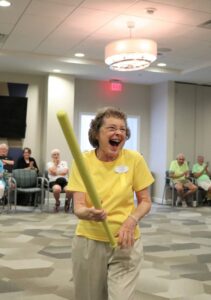 Senior woman holding bat and laughing