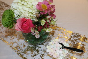 Close up on a tabletop floral arrangement and bowl of mints.