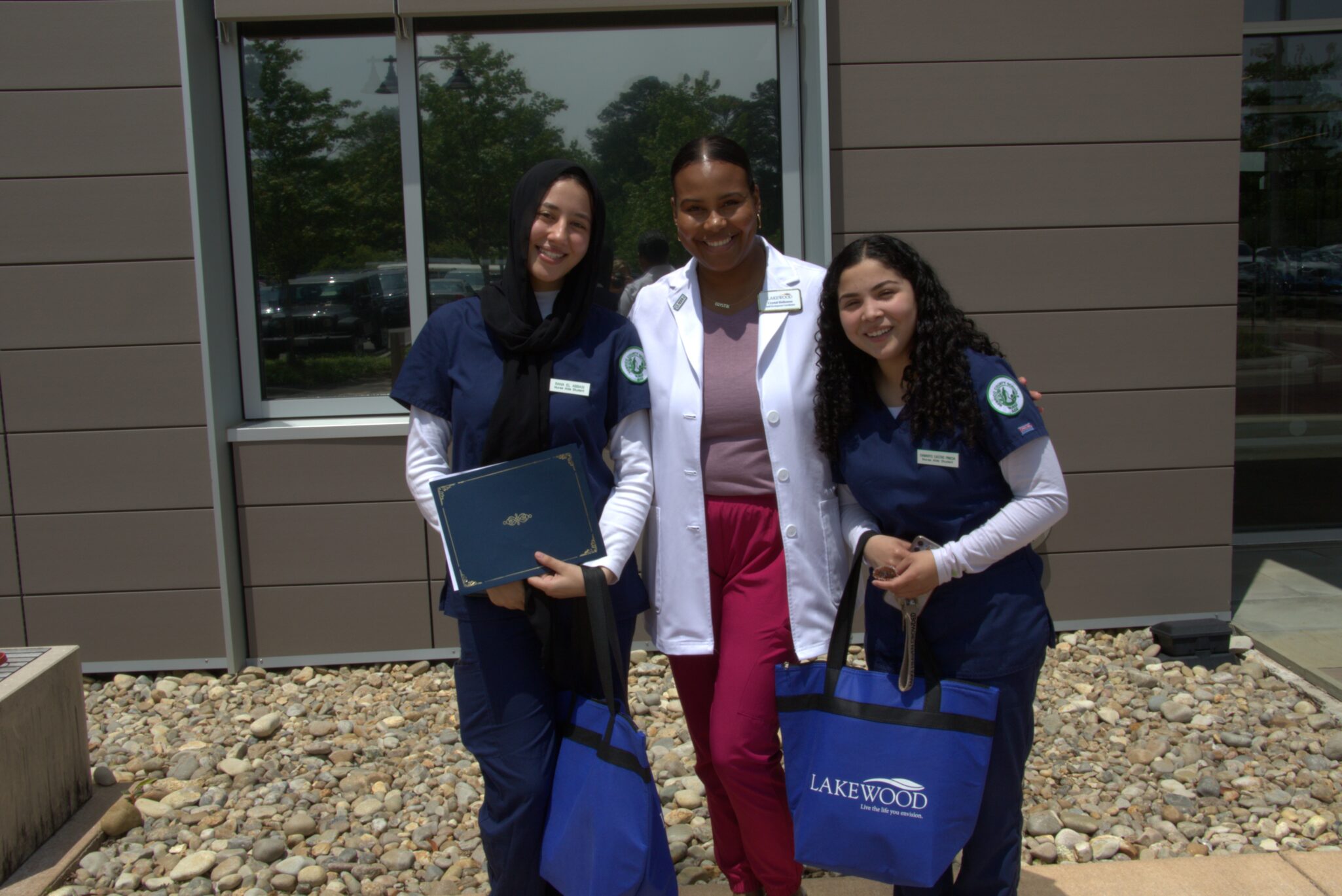 The Lakewood team is thrilled to announce 21 newly hired Certified Nursing Assistants (CNAs) through a partnership with Henrico Career and Technical Education (CTE). Three of the nurses pose for a photo.