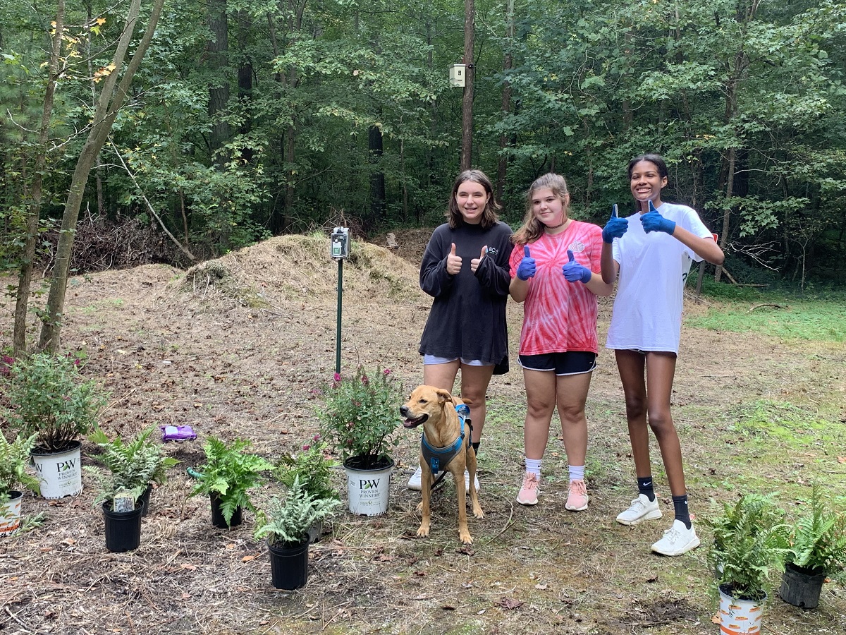 Three Girl Scouts give the thumbs up for a photo