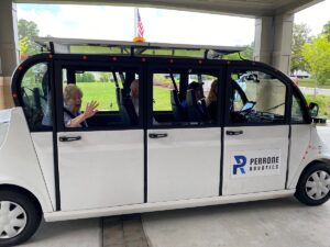 Senior woman waving from self-driving car