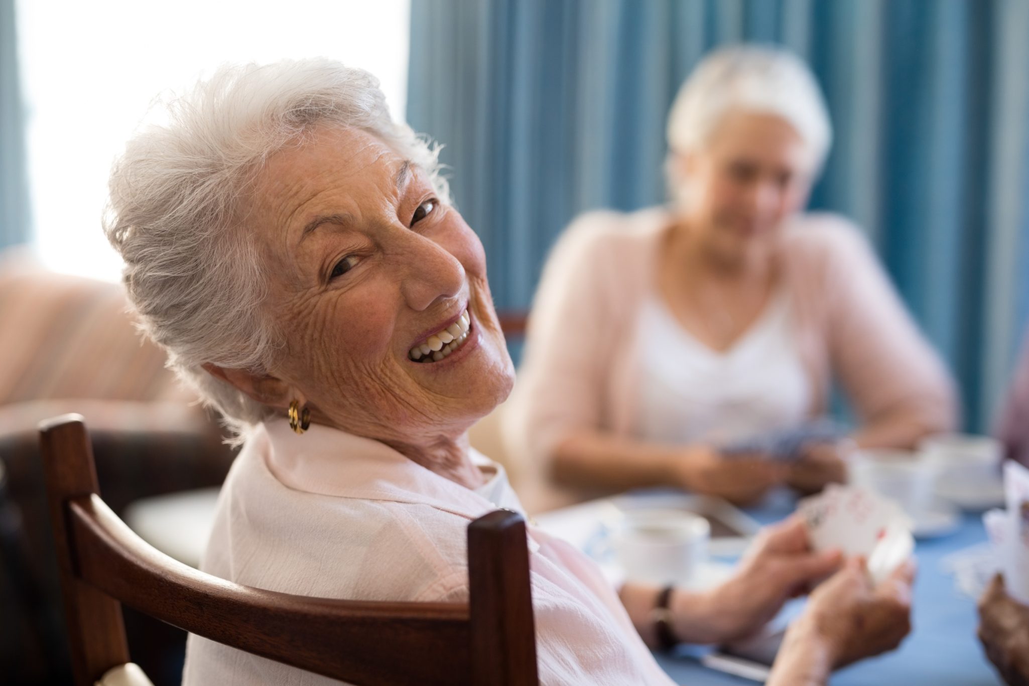 senior woman playing cards at Lakewood in Richmond, VA.