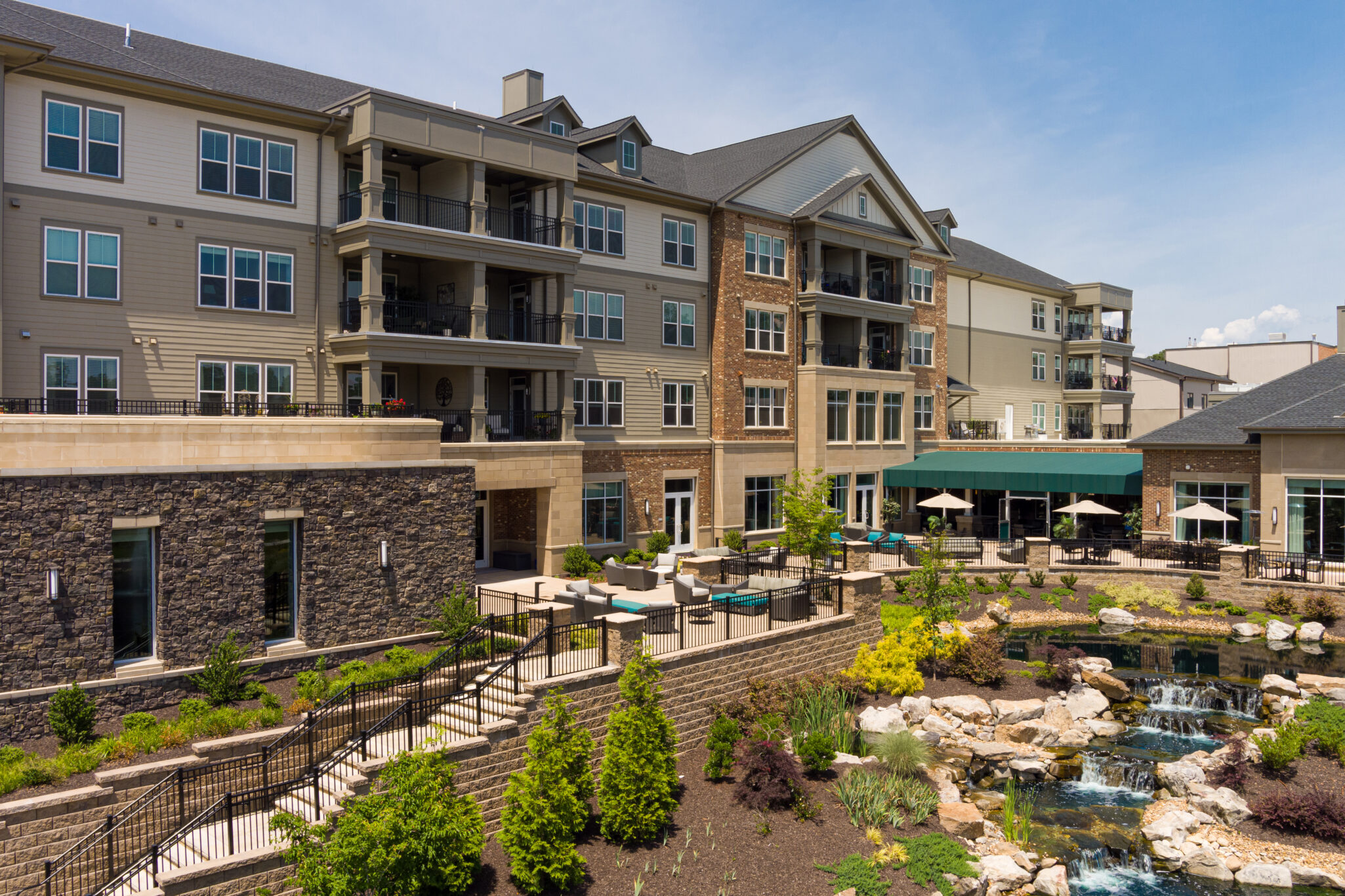 A photo of Lakewood retirement community with a waterfall landscaping and apartments