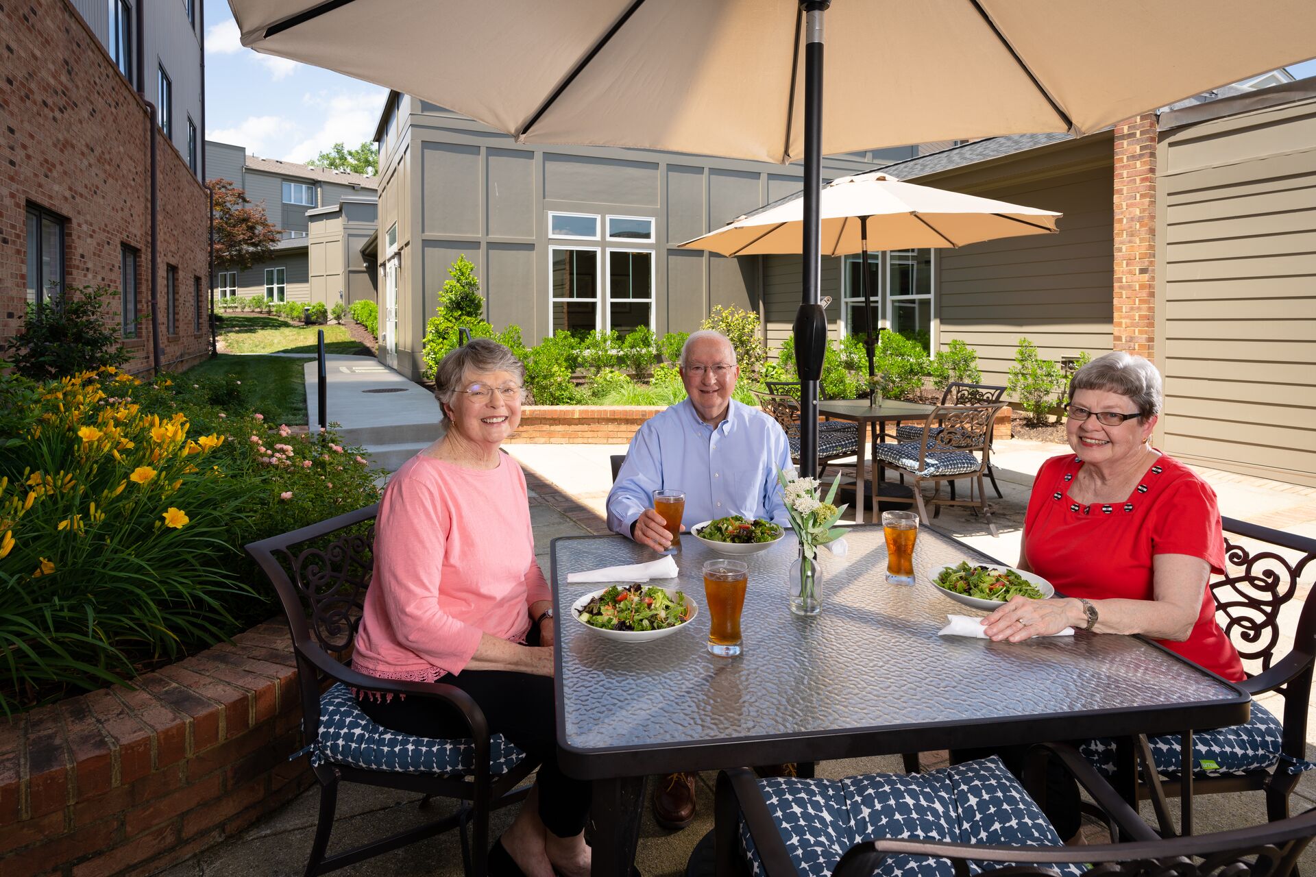 Senior residents enjoying a delicious lunch on the patio at Lakewood.