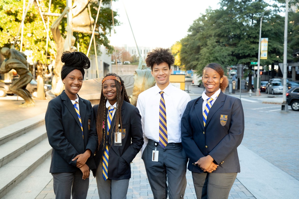 four high school students smiling at the camera