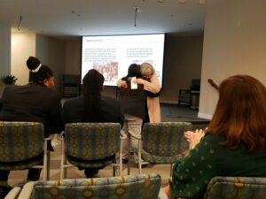 Teen work study participant embraces a resident.