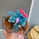 A close up photo of a ribbon and flower hat