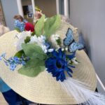 A close up photo of a sun hat decorated with blue and white flowers