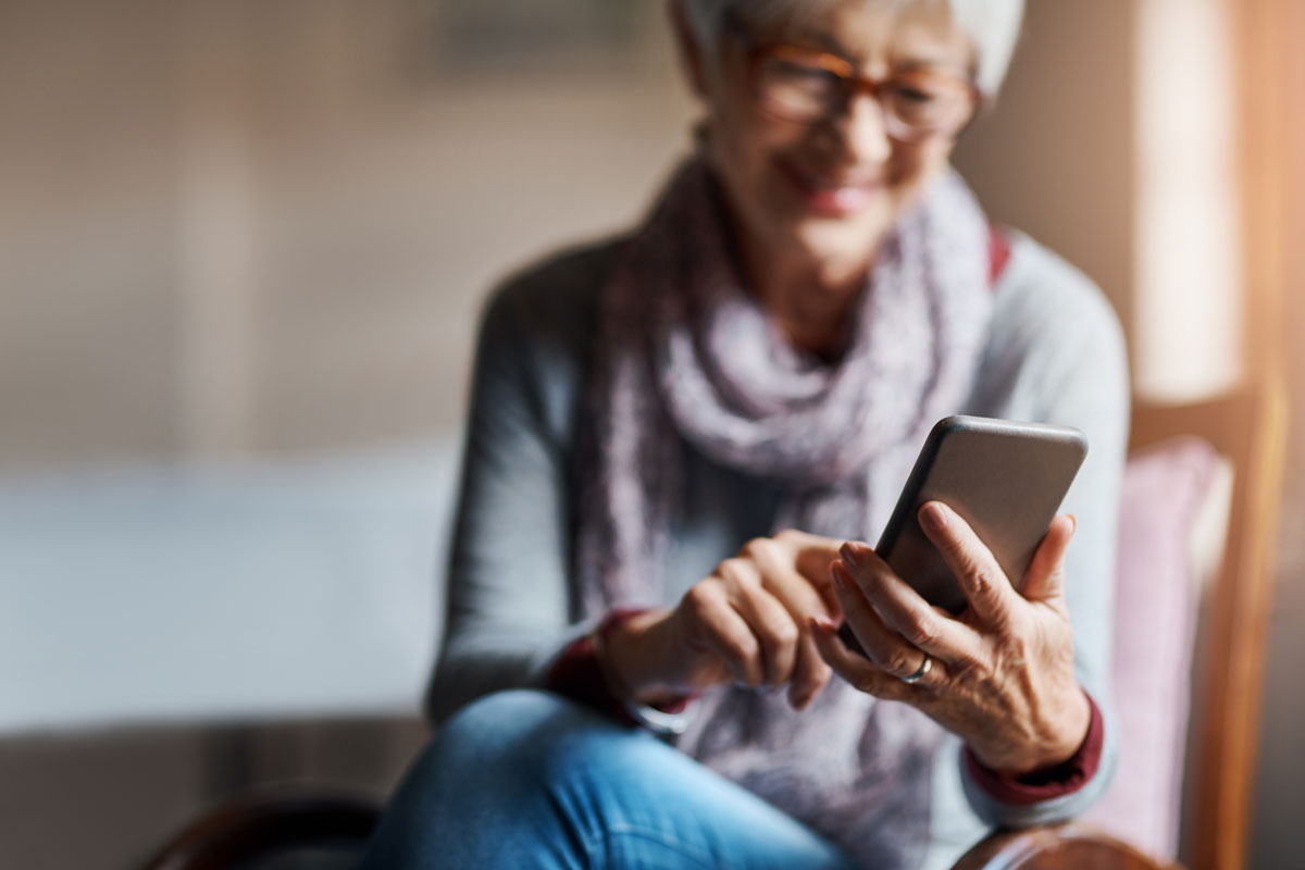 Senior woman uses technology during social distancing to keep in touch with loved ones.