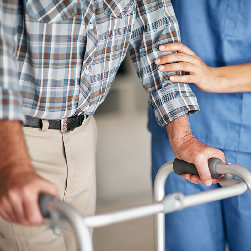 Senior man on walker with a skilled nurse